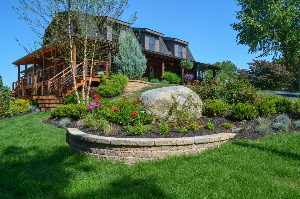 Peabody maintained residential lawn framed by layered planting, ornamental trees, and a garden path